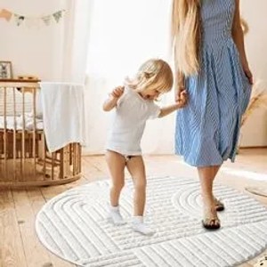 Runder, pastell-cremefarbener Hochflor Teppich Nara mit Rautenmuster im Kinderzimmer.