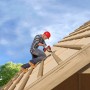 Handwerker befestigt Holz mit Fischer Holzschrauben auf einem Dachstuhl.