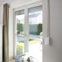 Schellenberg Aufschraubwickler Mini, schwenkbar, weiß, mit Rollladengurt an einem Fenster montiert.