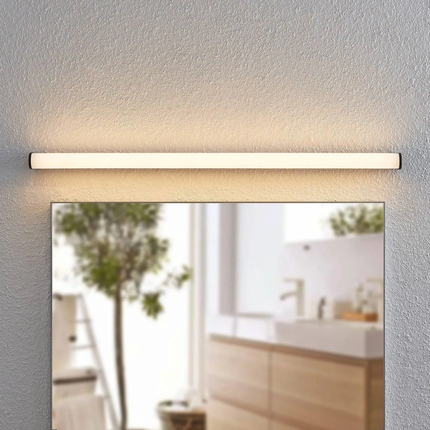 Schwarze Lindby LED Bad Wandleuchte Ulisan, spritzwassergeschützt, über einem Spiegel montiert.