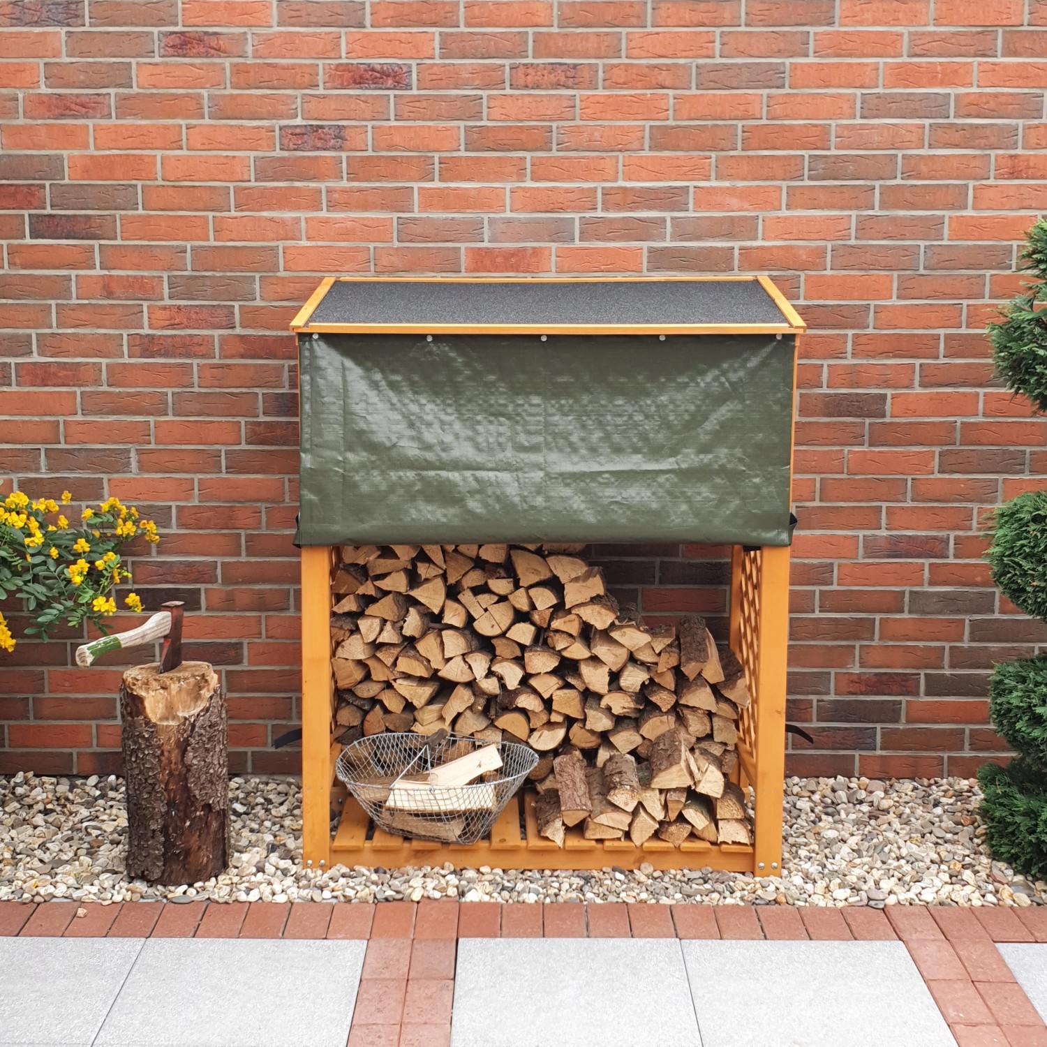 Honigbraunes Kaminholzregal Speyer mit Wetterschutz und Holzfüllung vor einer Backsteinwand.