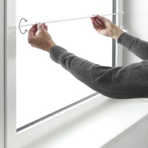 Montage einer weißen Gardinia Klemmstange (2er-Pack) im Fensterrahmen. Ausdrehbar von 35 bis 45 cm.