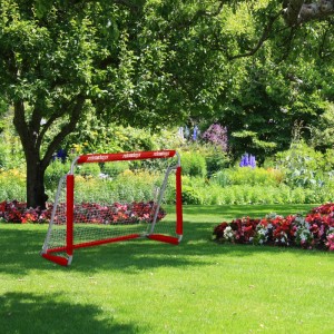 Rotes Fußballtor aus Eisen mit weißem Netz im Garten. Perfekt für Sport & Training von Kindern und Erwachsenen.