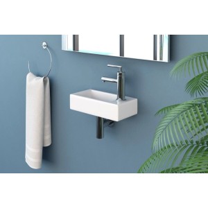 Weißes, kompaktes NEG Hänge-Waschbecken Uno41H mit Armatur rechts an blauer Wand, ideal für Gäste-WC.