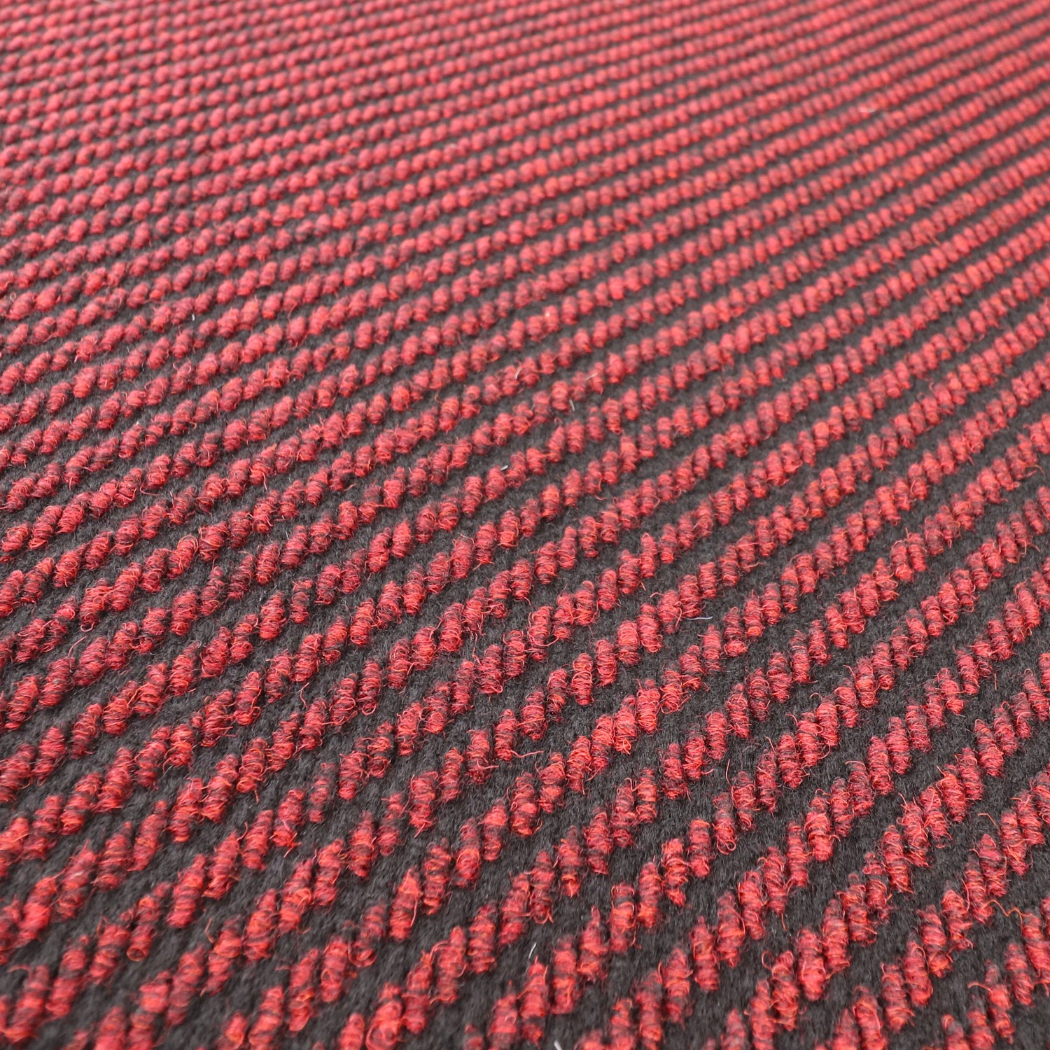 Nahaufnahme des roten Primaflor Sauberlauf Nordic Stripes Teppichläufers mit diagonalen Streifen und robuster Polypropylen-Oberfläche.