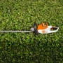 Stihl Akku-Heckenschere HSA 50 (ohne Akku/Ladegerät) vor grüner Hecke.