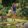 Einhell Aquinna 18/30 Akku-Wasserpumpe im Einsatz: Frau bewässert Garten mit Gartenschlauch.