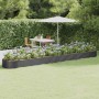 Anthrazitfarbenes Furnicato Hochbeet aus verzinktem Stahl (544x100x36 cm) im Garten mit Blumen.