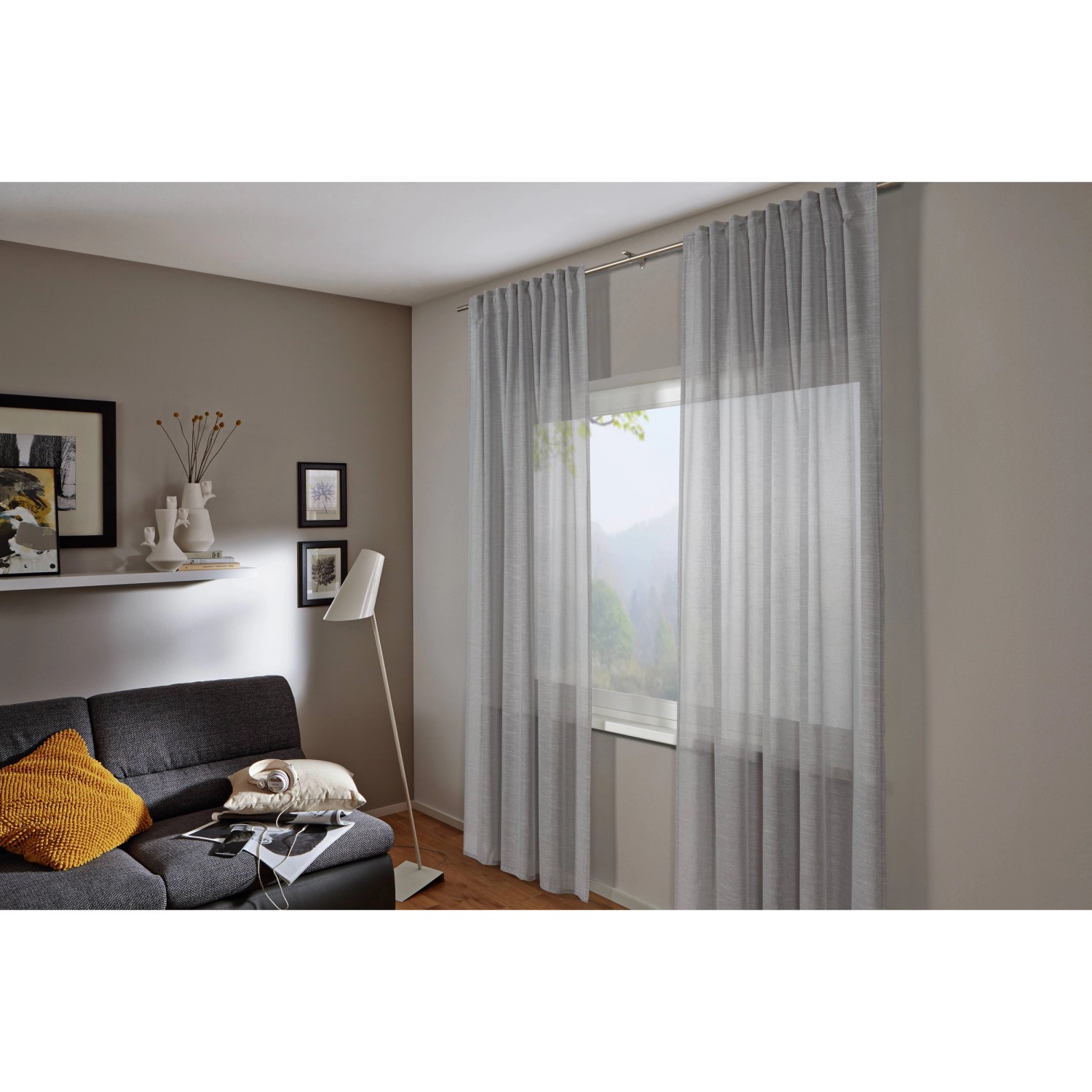 Blickdichter, silbergrauer Bennetti Schal mit Gardinenband Struktur vor Fenster im Wohnzimmer.