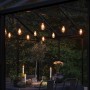 Konstsmide LED-Lichterkette Outdoor Retro mit 10 bernsteinfarbenen LEDs über gedecktem Tisch.