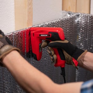 Roter Arrow Elektrotacker CE21 beim Tackern von Folie an einer Wand.