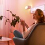 Frau entspannt mit WiZ LED Strip (Tunable White & Color) im Wohnzimmer.