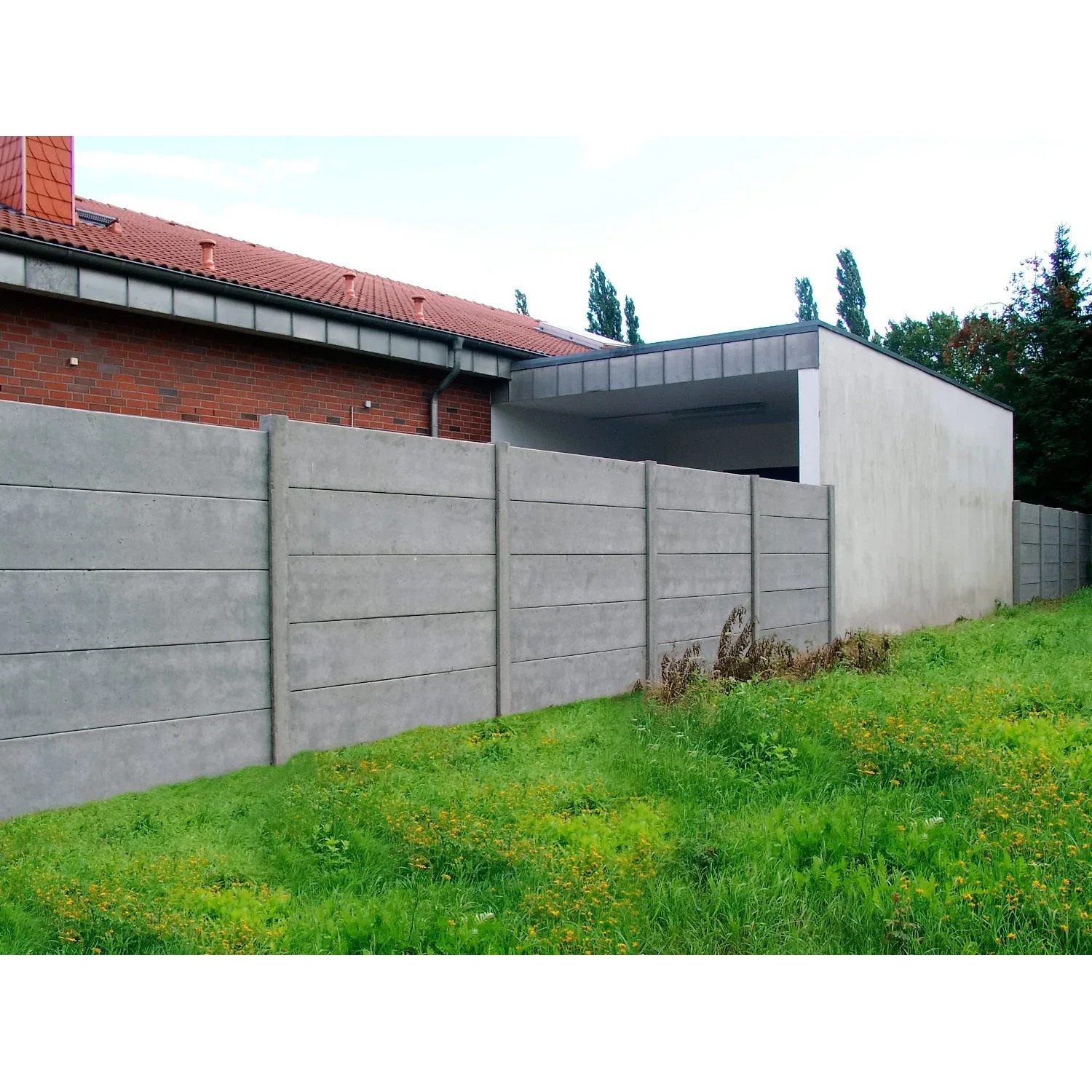 Graue Betonzaun-Platte (200x38,5x3 cm) als Sichtschutz im Garten.