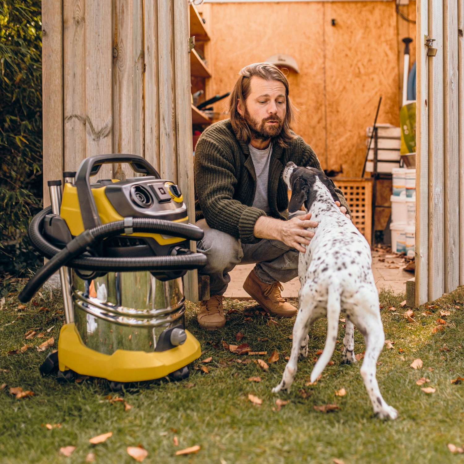 Kärcher Nass-Trockensauger WD 6 P S V-30/6/22/T mit Mann und Hund im Garten.