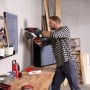 Handwerker bohrt mit roter Einhell Akku-Schlagbohrmaschine in Wand. Kabellose Bohrmaschine für Heimwerker.