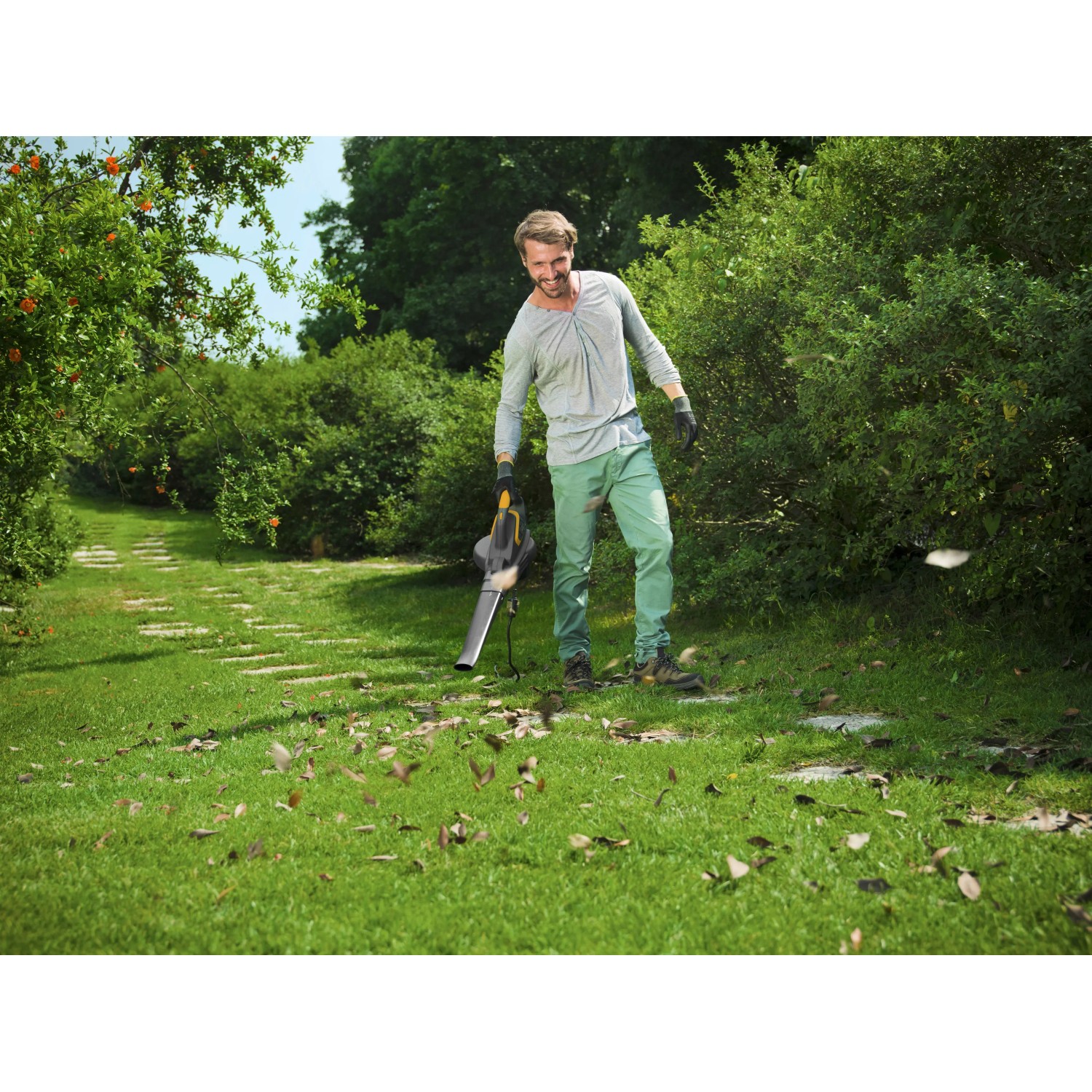 Mann benutzt Stiga Elektro-Laubbläser BL 130c V im Garten.