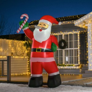 Großer aufblasbarer Weihnachtsmann mit Zuckerstange, rot, beleuchtet, als festliche Weihnachtsdekoration vor einem Haus.