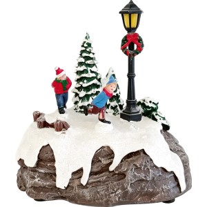 Weihnachtsdorf Szene: Eisläufer, Kind, Tannenbäume und beleuchtete Laterne mit Kranz auf schneebedecktem Hügel. Weihnachtsdekoration.