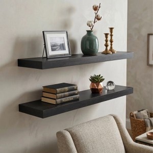 Schwarzes Relaxdays Wandregal 3er Set aus MDF und Eisen, dekoriert mit Büchern und Pflanzen.