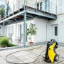 Kärcher Hochdruckreiniger mit Verlängerungsschlauch XH 10 Q im Einsatz vor Hausfassade.