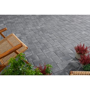 Verlegtes Betonpflaster Vero in Anthrazit-Grau nuanciert, mit Gartenmöbeln und Pflanzen dekoriert.