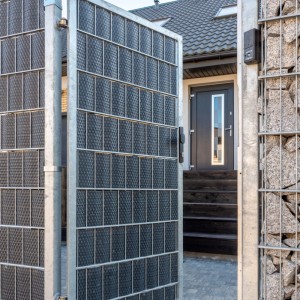 Geöffneter grauer Zaun mit Primaflor Polyrattan Sichtschutzstreifen im Garten.