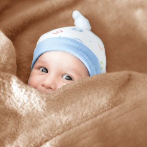Baby in beiger Bestlivings Mikrofaser Babydecke (90x140 cm) eingewickelt.