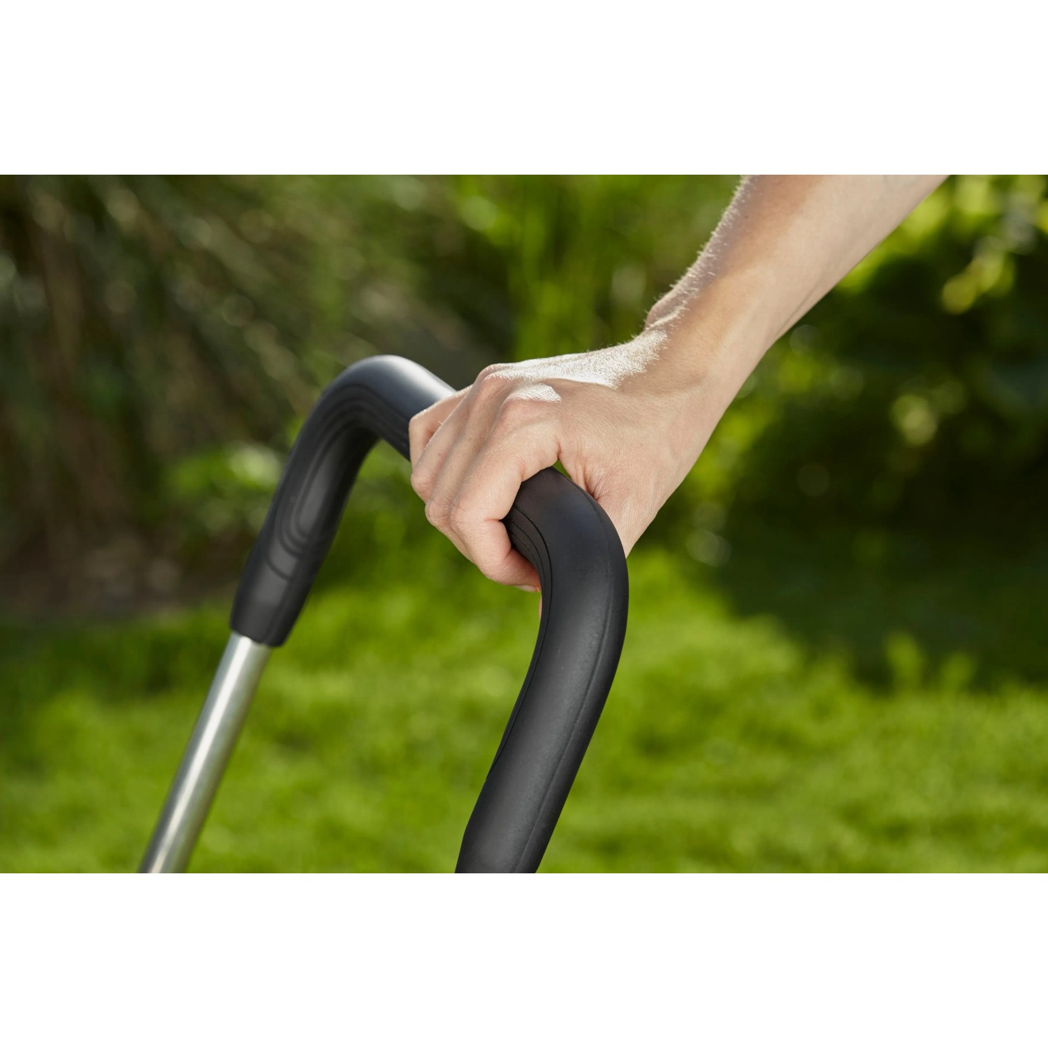 Hand hält Griff des Gardena CleverRoll M Easy Schlauchwagens.