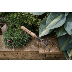 Kent & Stowe Hand-Grubber mit 3 Zinken aus Carbonstahl und Holzgriff im Beet.