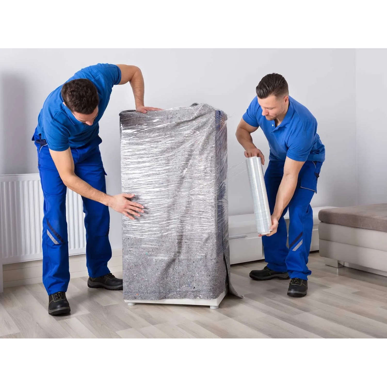 Zwei Männer verpacken Möbel mit Primaflor Möbelpackdecken und Folie für den Umzug.