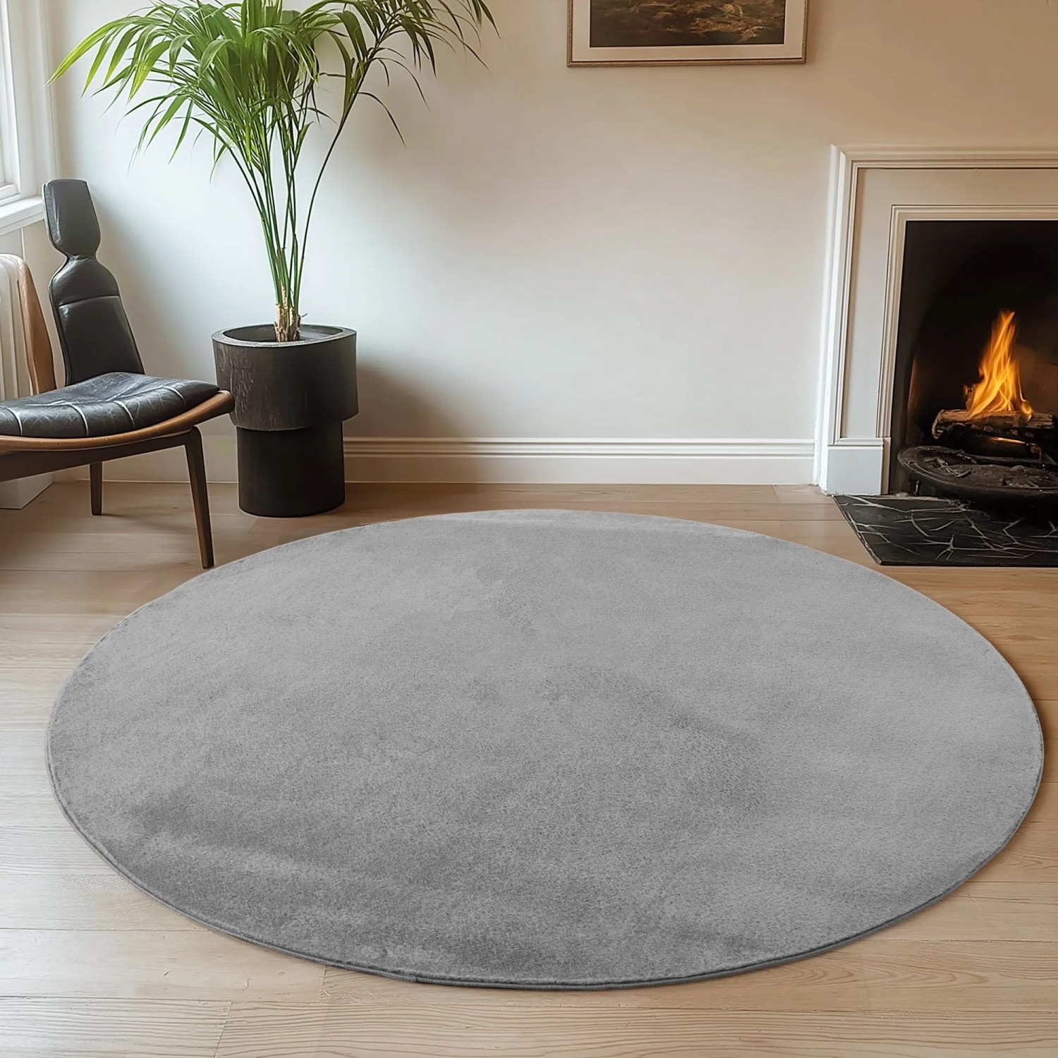 Runder, grauer Ayyildiz Kurzflorteppich Joy (Ø 120 cm) im Wohnzimmer.