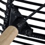Detailaufnahme: Schwarzer Esszimmerstuhl mit Rattan und Holzbeinen.