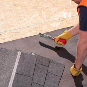 Handwerker befestigt Dachpappe mit Arrow Hammertacker HT19. Der Tacker ist ideal für schnelle Serienbefestigungen.
