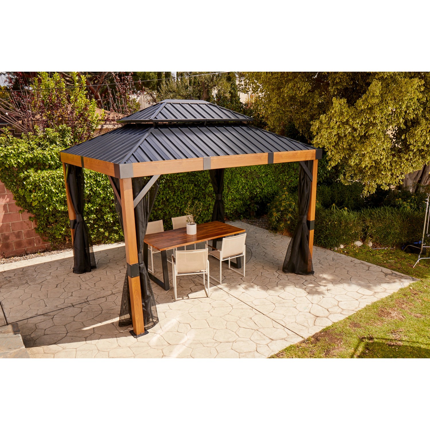 Sojag Pavillon Fontana 289x363 cm mit Moskitonetz und Esstischgruppe im Garten.