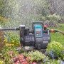 Gardena Garten- und Hauswasserautomat 5000/5 LCD im Einsatz, bewässert Garten mit Blumen.