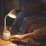Weiße Philips LED Schreibtischleuchte Hat mit Stiftehalter und Hand am Schalter.