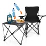 Camping Set: Faltbarer Campingtisch mit Stühlen, schwarz. Tisch mit Lampe, Getränken und Snacks.