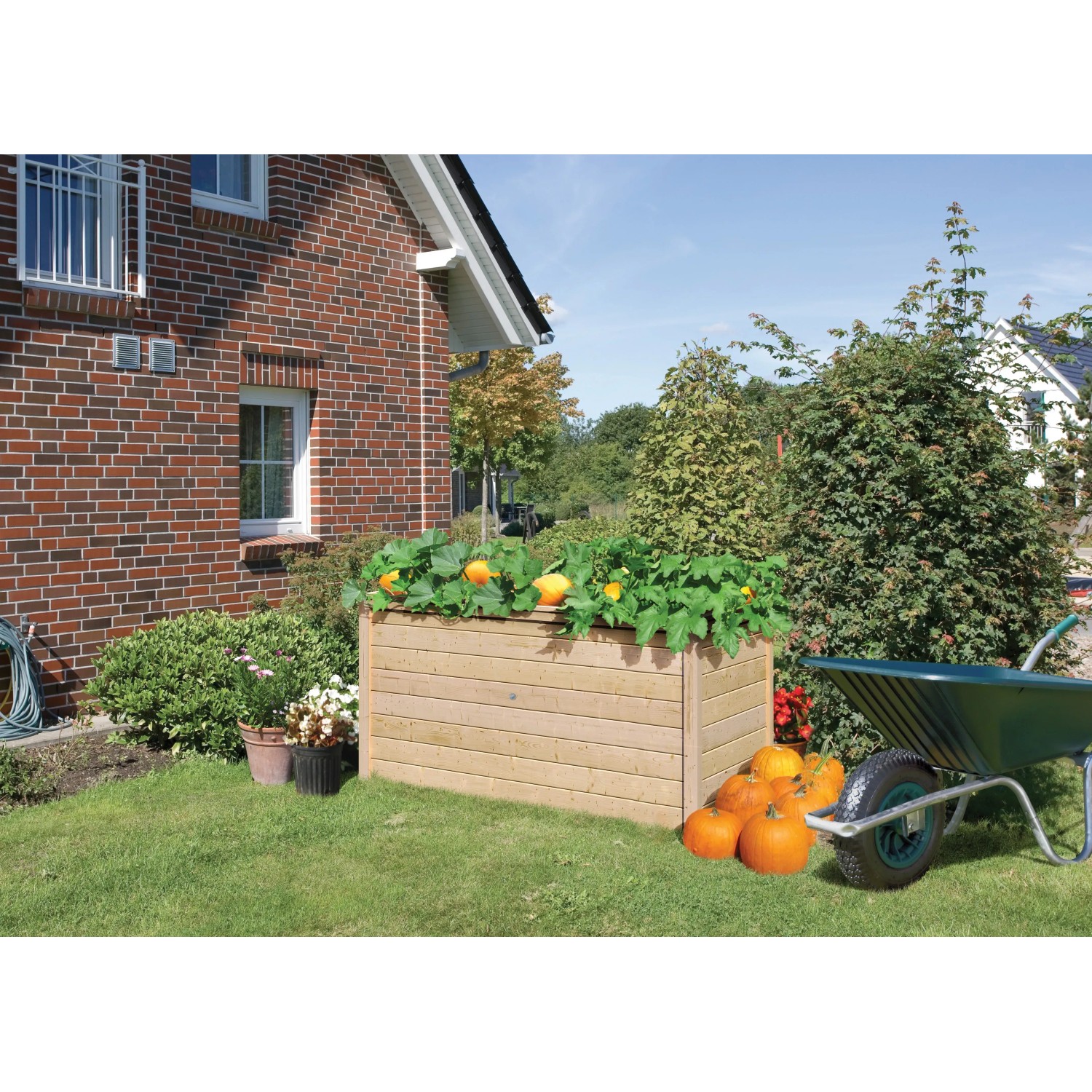 Karibu Hochbeet aus Fichte, naturbelassen, mit Bepflanzung und Kürbissen im Garten.