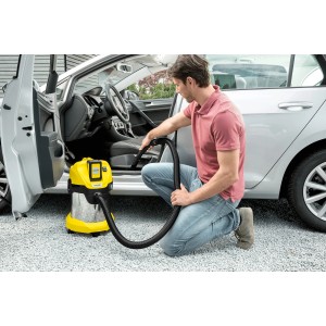 Mann saugt Auto mit gelbem Kärcher Akku-Mehrzwecksauger WD 3 Battery Premium.