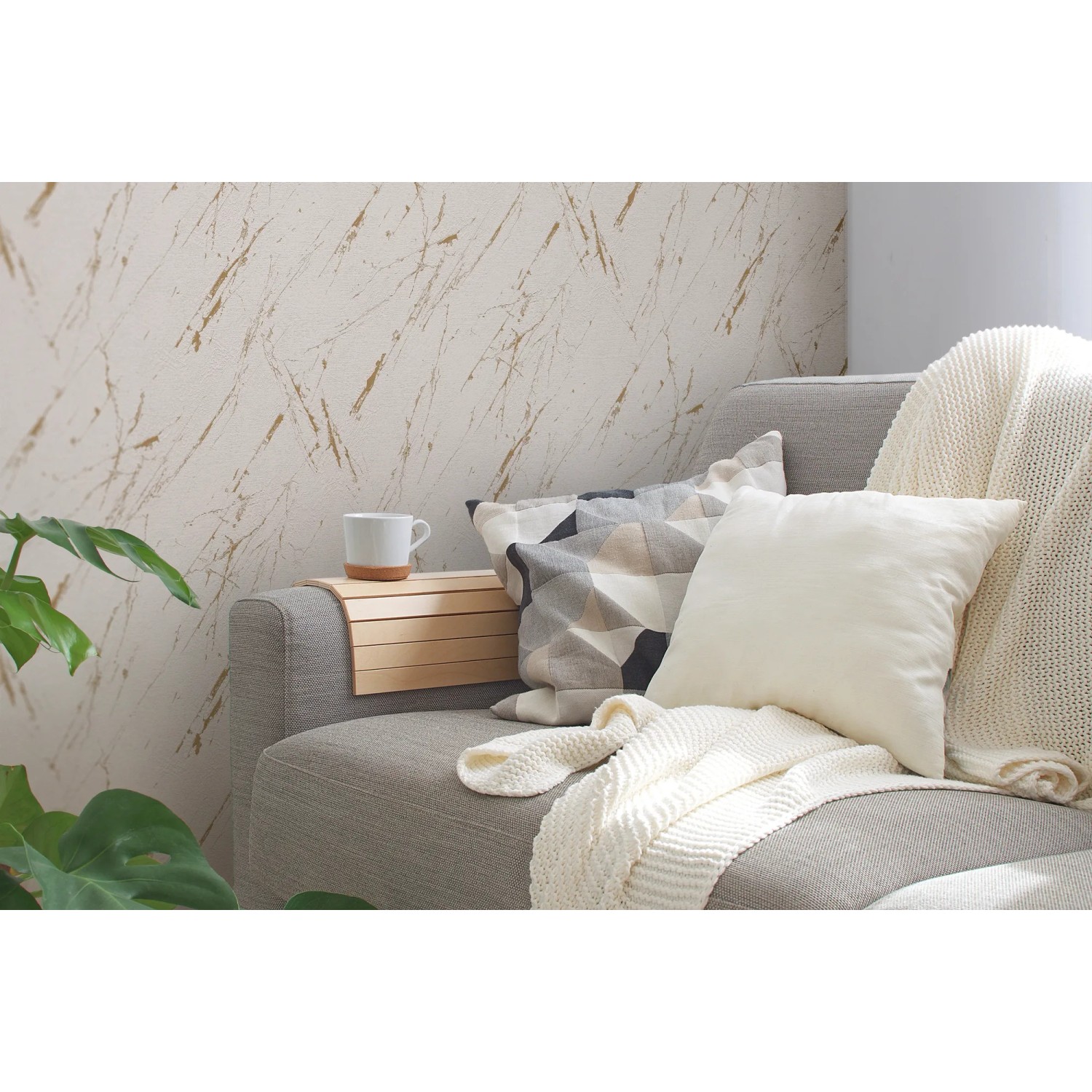 Beige-goldene Vliestapete in Marmoroptik von A.S. Création an Wohnzimmerwand.