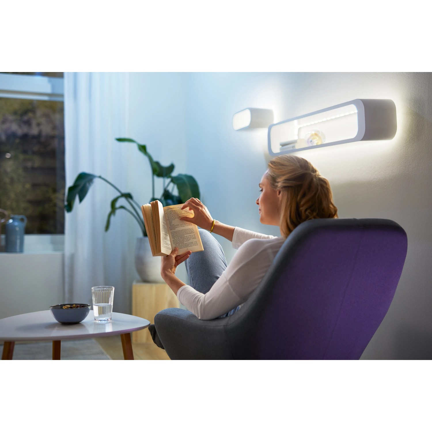 Frau liest unter WiZ LED Strip Licht. Smartes, flexibles Leuchtmittel für stimmungsvolle Beleuchtung.