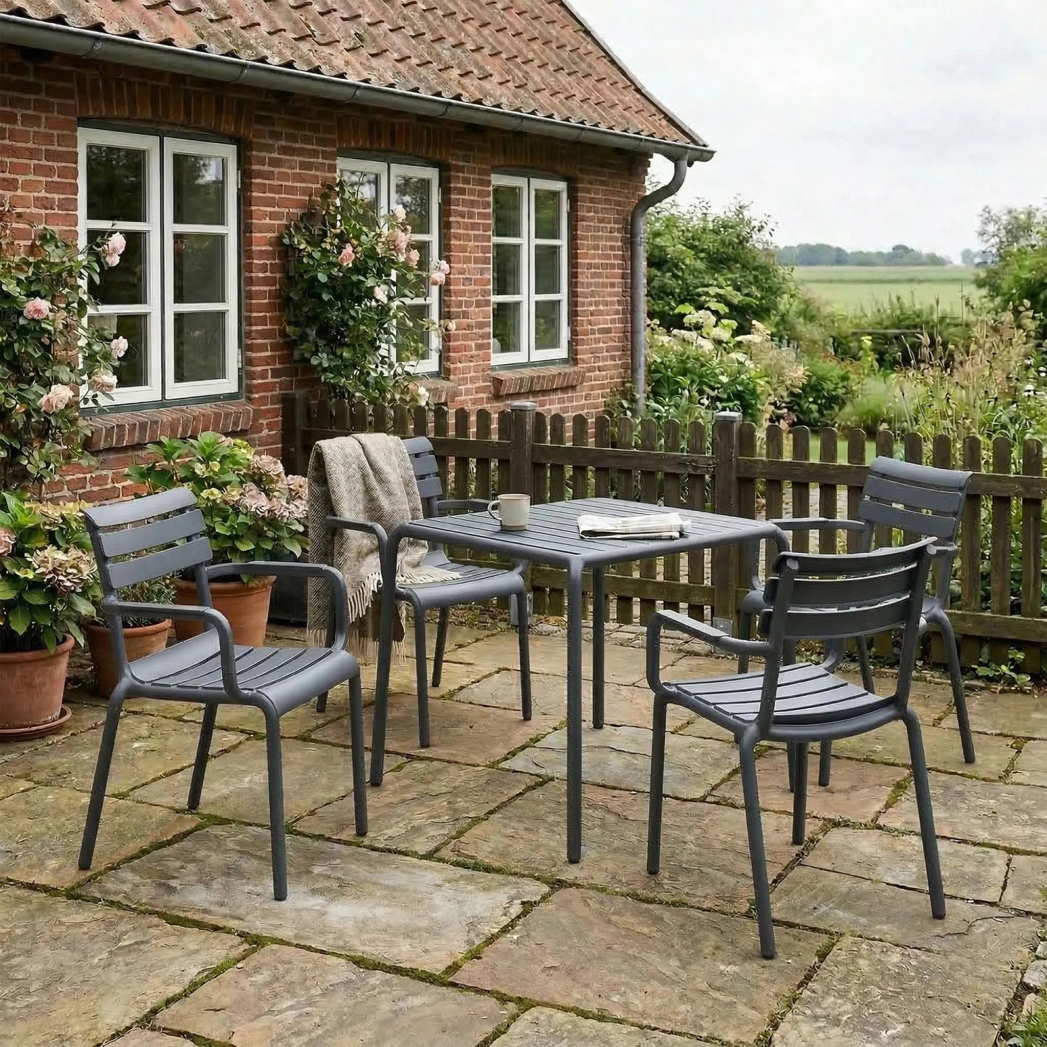 Dunkelgraue DELUKE LARS Gartenstühle aus Kunststoff auf einer Terrasse, stapelbar. Ideal für Outdoor.