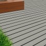 Hellgraue WPC Terrassendielen (2,1x14,5x300 cm) mit geriffelter Oberfläche auf Terrasse verlegt.