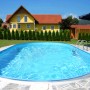 Ovaler Summer Fun Stahlwandpool FERRARA (525x320x120 cm) im Garten mit Haus.