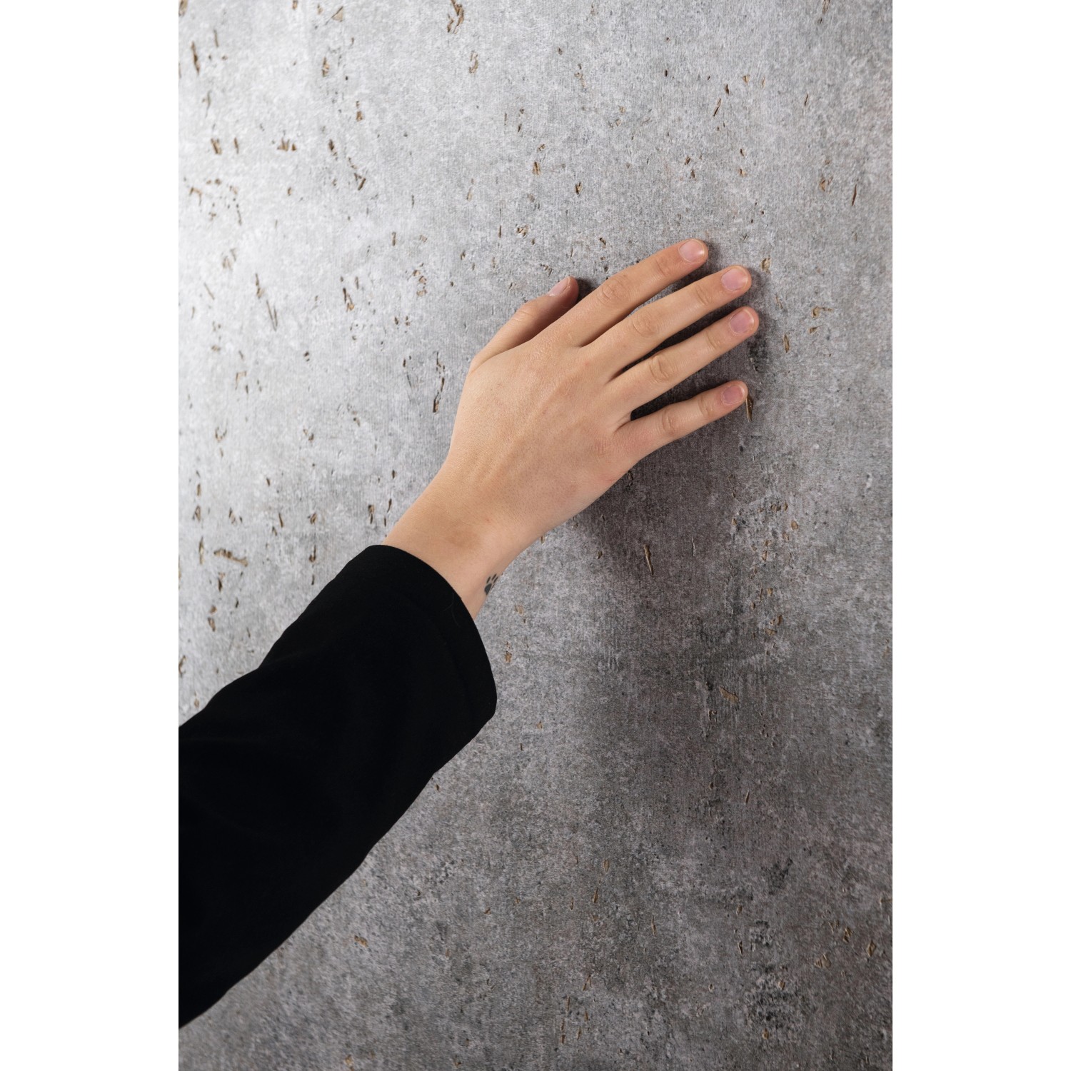 Egger DecoWall Wandpaneel Rovigo Beton, graue Dekor-Paneele mit Hand im Detail.