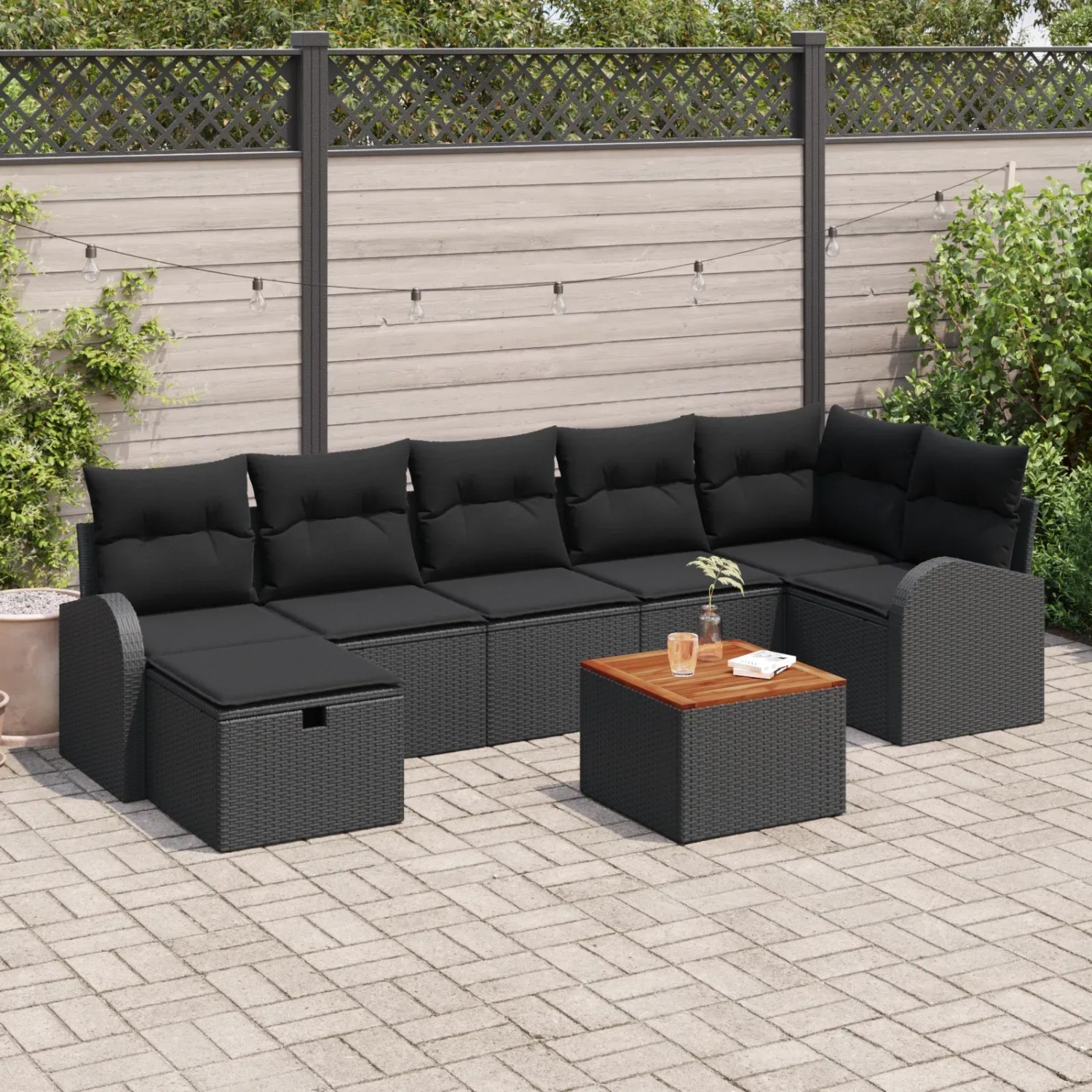 Schwarzes 8-teiliges Garten-Sofa-Set aus Poly Rattan mit Kissen und Tisch.