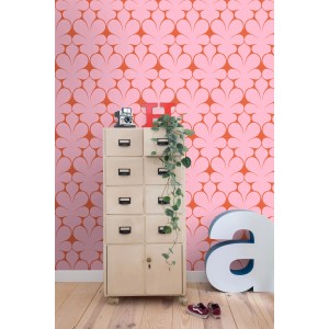 Rosa Vliestapete mit roten Retro-Ornamenten an einer Wand, die einen stilvollen Wohnraum dekoriert.