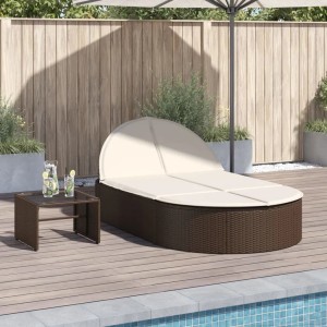Braune Doppel-Sonnenliege aus Rattan mit cremefarbenen Auflagen und Beistelltisch im Garten.