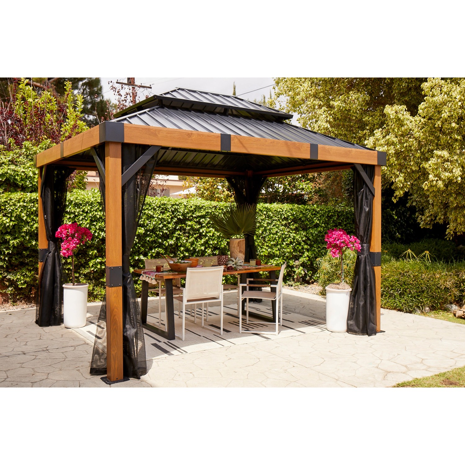 Sojag Pavillon Fontana 289x363 cm mit Moskitonetz und Esstisch im Garten.