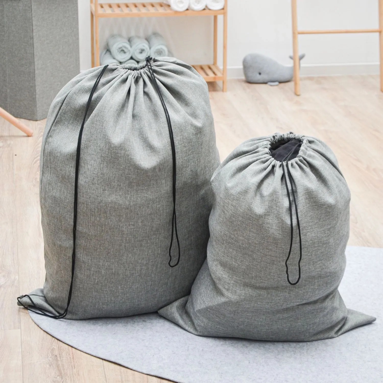 Zwei graue Wäschesäcke, 100L & 60L, mit Kordelzug. Stoff im Leinen-Look für Waschen & Trocknen.
